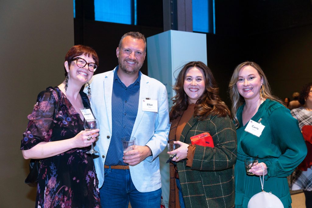 Five people standing together and smiling at a Grand Rapids Community Foundation event.