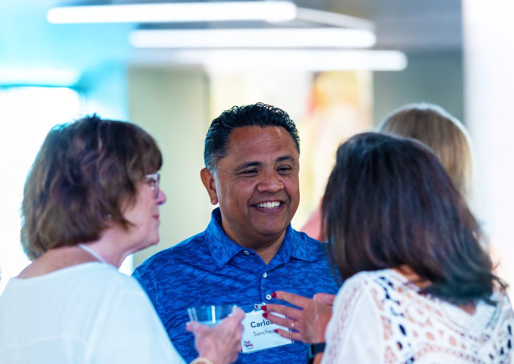 A small group of attendees talking and smiling together at a Grand Rapids Community Foundation convening.